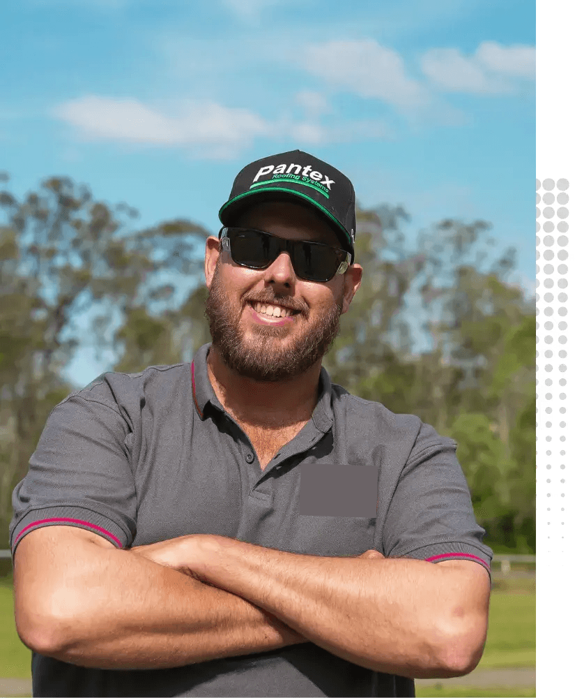 Kingpin Engineering team member standing outdoors in a grey company polo shirt with arms crossed.